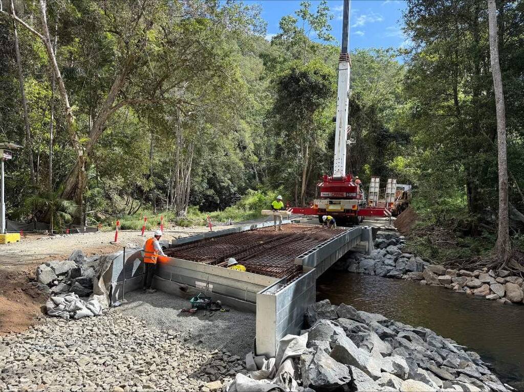 Local crews install the flat‑pack bridge at Rowlands Creek, a design that speeds up construction at remote sites